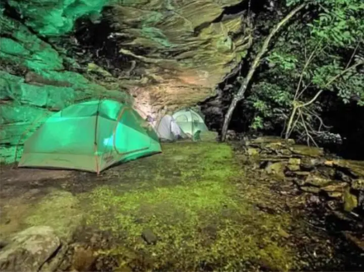 Camping under a cliff at night