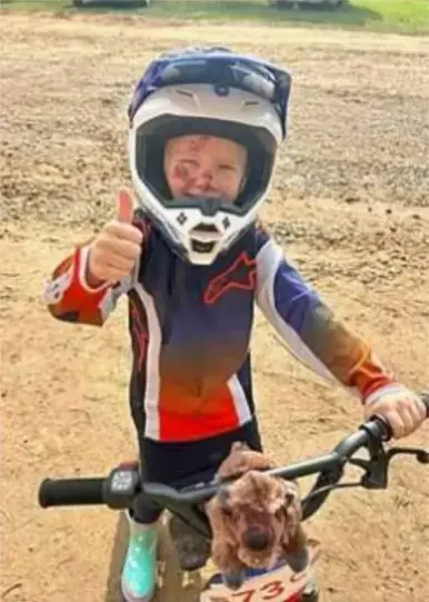 Child on a bike giving thumbs up
